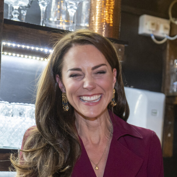 Le prince William, prince de Galles, répond à l'appel d'un client du restaurant, sous le regard de Catherine (Kate) Middleton, princesse de Galles, lors d'une visite à l'Indian Streatery, un restaurant indien familial à Birmingham, le 20 avril 2023. Ils célèbrent la riche culture asiatique de la ville. 
