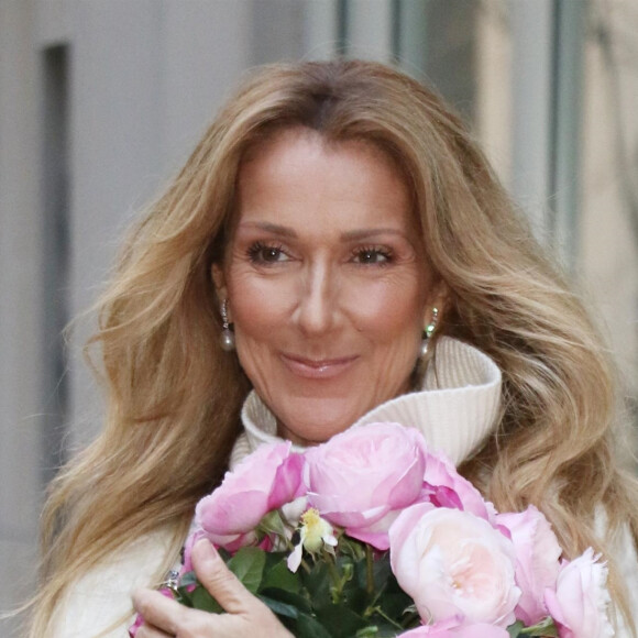 Un "syndrome de l'homme raide" qui l'handicape toujours.
Celine Dion rayonnante et très souriante dans un ensemble pull écru et jupe bouffante fleurie salue ses fans à la sortie de son hôtel à New York, le 8 mars 2020 