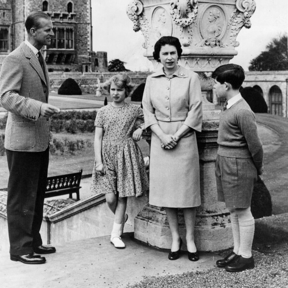 Archives - La reine Elisabeth II d'Angleterre et le prince Philip, duc d'Edimbourg, avec leurs enfants, le prince Charles et la princesse Anne, sur la terrasse du château de Windsor. Juin 1959 