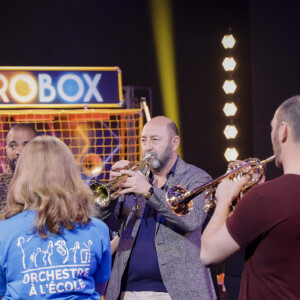 Au programme : des confidences et des jam sessions.
Exclusif - Ludovic Louis, Kad Merad - Enregistrement de l'émission "Improbox", présentée par I.Maalouf et diffusée le 24 juin à 19h sur Canal+ © Jack Tribeca / Bestimage IMPROBOX 5 émissions de 30 minutes Produites par Électron Libre Productions et Mister Ibé Sur une idée originale d'I.Maalouf Première émission avec K.Merad, parrain de cette nouvelle émissionDeux émissions à la suite à 19H00 les samedis 24 juin, 1er et 8 juillet EN CLAIR sur CANAL+ et disponible sur myCANAL Le musicien I.Maalouf présente en exclusivité et à l'occasion de la fête de la musique, un concept d'émission musicale inédit, accueillant tour à tour 5 invités exceptionnels pour une expérience rare ! Entouré de musiciens talentueux et d'un public inédit muni lui­ aussi d'instruments de musique, I.Maalouf, qui pour l'occasion devient présentateur, invite les 5 personnalités à relever un défi musical unique : apprendre à jouer d'un instrument et créer une composition avec, et ce pour la première fois de leur vie. Le tout en représentant une association de leur choix à qui ils reversent les droits de leur création. Dans un décor unique, les invités participent à une succession de jeux afin d'amorcer leur entraînement et bénéficient d'un coaching de haut niveau, puis vivent l'expérience de la création en instantané ! En fin d'émission, c'est tout le public d'IMPROBOX qui participe au live interprété par l'invité, Ibrahim et tous les musiciens présents. 