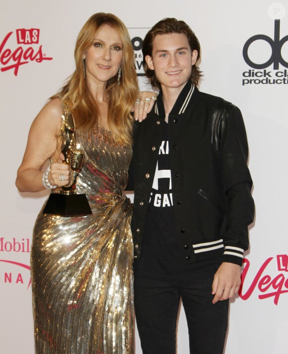 Casquette sur la tête, chaîne et pendentif Louis Vuitton, il affiche un large sourire en pleine partie de poker.
Céline Dion et son fils René Charles Angélil au press room de la soirée Billboard Music Awards à T-Mobile Arena à Las Vegas, le 22 mai 2016.
