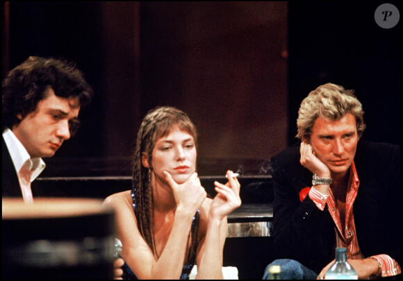 Archives - Michel Sardou, Jane Birkin et Johnny Hallyday sur le plateau de l'émission de TF1 "Numéro 1 à Michel Sardou" en 1975.
