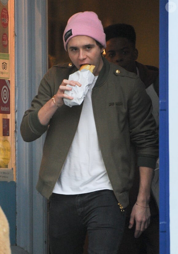 Exclusif - Brooklyn Beckham mange un sandwich alors qu'il passe son après-midi avec des amis à Londres. Le 2 février 2017