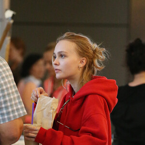 Lily-Rose Depp fait la queue au comptoir "The Coffee Bean" à l'aéroport de Los Angeles, commande puis mange un snack avec une boisson rapidement avant d'aller prendre un avion accompagnée de son garde du corps le 22 mai 2016.