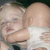 Avec sa poupée, la petite fille est trop mignonne. 