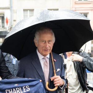 Le président du PSG (Paris Saint Germain) Nasser al-Khelaïfi offre un maillot du club au roi Charles III d'Angleterre lors d'une visite à Saint-Denis le 21 septembre 2023. 