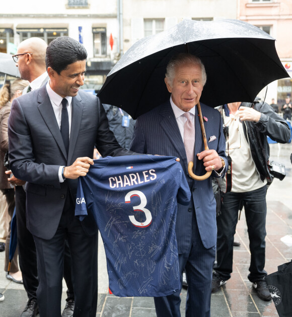 Le président du PSG (Paris Saint Germain) Nasser al-Khelaïfi offre un maillot du club au roi Charles III d'Angleterre lors d'une visite à Saint-Denis le 21 septembre 2023. 