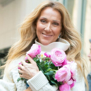 Céline Dion est victime du syndrome de la personne raide
Céline Dion rayonnante et très souriante dans un ensemble pull écru et jupe bouffante fleurie salue ses fans à la sortie de son hôtel à New York