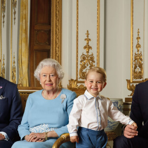 C'est le prince William puis le prince George. 
La reine Elisabeth II a posé, à l'occasion de son 90ème anniversaire, avec son fils le prince Charles, son petit-fils le prince William et son arrière petit-fils le prince George, pour quatre nouveaux timbres de la Royal Mail, au palais de Buckingham à Londres. 