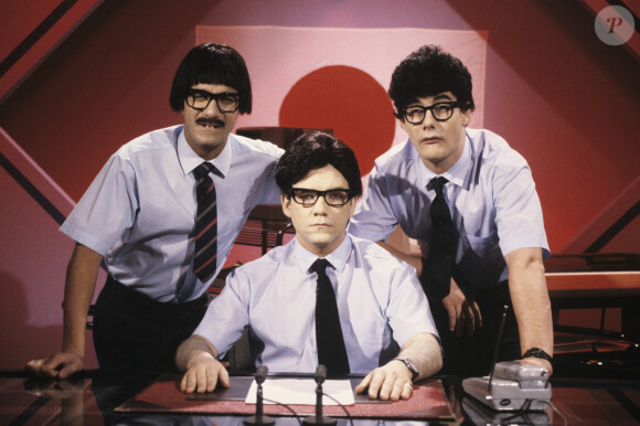 Archives - Les Inconnus - Pascal LEGITIMUS, Didier BOURDON assis et Bernard CAMPAN, déguisés en journalistes japonais en mars 1990.