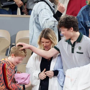 Roman et Aliocha Haroche voient Carlos Alcaraz dédicacer leurs casquettes sous le regard de leurs parents, Mélanie Thierry et son compagnon Raphaël - Les célébrités dans les tribunes des Internationaux de France de tennis de Roland Garros 2024 à Paris, le 29 mai 2024. © Jacovides / Moreau / Bestimage 