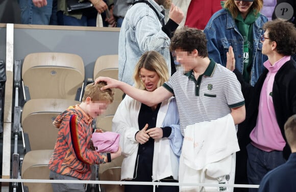 Roman et Aliocha Haroche voient Carlos Alcaraz dédicacer leurs casquettes sous le regard de leurs parents, Mélanie Thierry et son compagnon Raphaël - Les célébrités dans les tribunes des Internationaux de France de tennis de Roland Garros 2024 à Paris, le 29 mai 2024. © Jacovides / Moreau / Bestimage 