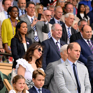 Mais la soirée ne s'est pas déroulée selon les plans. Interrogé par Hello!, un proche de la famille royal a déclaré que le trio n'avait pas pu se présenter à l'heure prévue.
Prince William, Prince George et Princesse Charlotte regardent la remise de prix faite par la Princesse de Galles à Wimbledon en Angleterre, le 16 juillet 2023