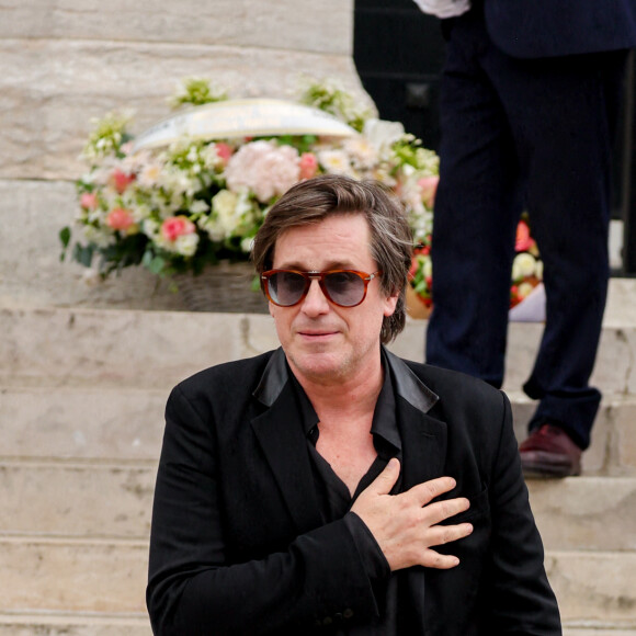 Un hommage essentiel pour Thomas Dutronc, qui n'était pas à Paris quand sa mère est morte. 
Thomas Dutronc, la main sur le coeur en guise de remerciement envers la foule d'admirateurs venue nombreuse pour rendre un dernier hommage à sa mère - Sortie des obsèques de l'auteure-compositrice-interprète et actrice française Françoise Hardy au crématorium du cimetière du Père-Lachaise à Paris, France, le 20 juin 2024. © Jacovides-Moreau/Bestimage 