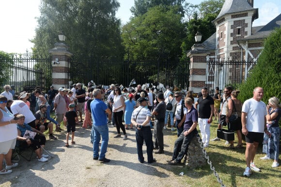 Les fans rendent hommage à Alain Delon devant la grille de sa propriété à Douchy-Montcorbon pendant ses obsèques le 24 août 2024. 