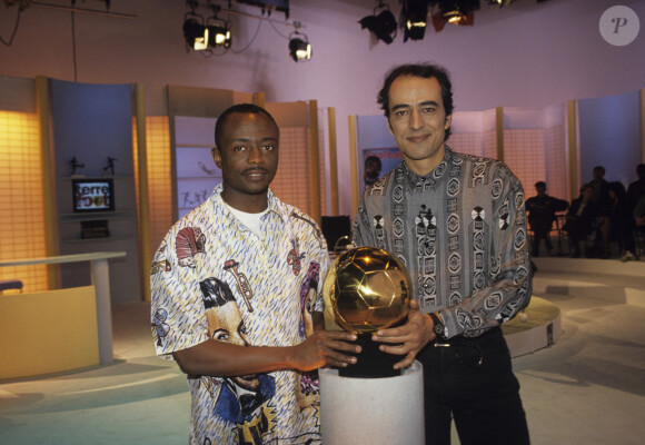 Archives - En France, à Paris, Abédi PELE posant avec son trophée BALLON D'OR AFRICAIN et Didier ROUSTAN