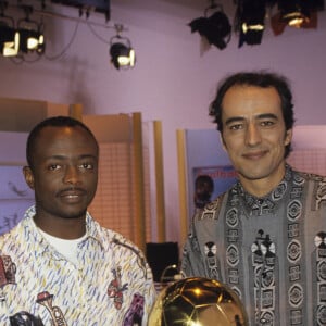 Archives - - En France, à Paris, Abédi Pelé posant avec son trophée Ballon d'Or africain et Didier Roustan.