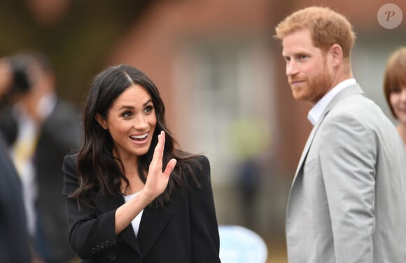 Le prince Harry, duc de Sussex et sa femme Meghan Markle, duchesse de Sussex saluent la foule lors de leur visite au collège de la trinité à Dublin le 11 juillet 2018 