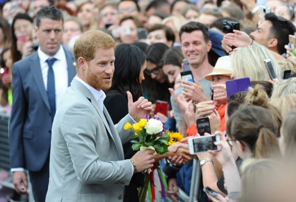 Le prince Harry, duc de Sussex et sa femme Meghan Markle, duchesse de Sussex saluent la foule lors de leur visite au collège de la trinité à Dublin le 11 juillet 2018 