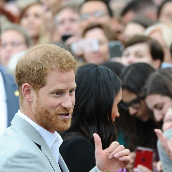 Le prince Harry, duc de Sussex et sa femme Meghan Markle, duchesse de Sussex saluent la foule lors de leur visite au collège de la trinité à Dublin le 11 juillet 2018 