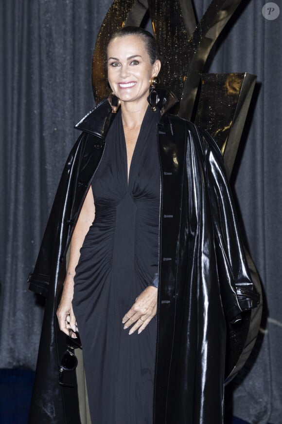 La mère de Jade et Joy a fait le choix d'une robe noire sculpturale et d'un joli trench en vinyl très chic. 
Laeticia Hallyday au photocall du défilé Saint Laurent, Collection Prêt-à-porter Printemps / Eté 2025 dans le cadre de la Fashion Week de Paris le 24 septembre 2024. © Olivier Borde / Bestimage