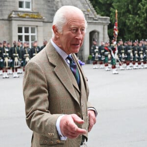 Le roi Charles III d'Angleterre, accueilli par des soldats de la compagnie Balaklava, 5e bataillon du Royal Regiment of Scotland devant le château de Balmoral (Ecosse), où le souverain débute ses vacances d'été, le 19 août 2024.