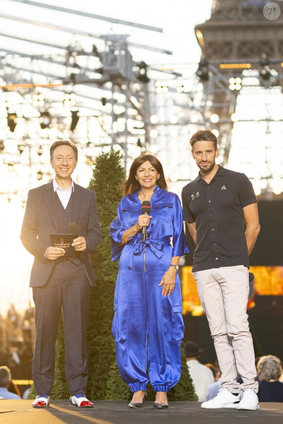 Exclusif - Stéphane Bern, Anne Hidaldo et Tony Estanguet lors du 10ème anniversaire du "Grand Concert de Paris" au pied de la Tour Eiffel sur le Champ-de-Mars à Paris, France, le 14 juillet 2023. © Perusseau-Veeren/Bestimage