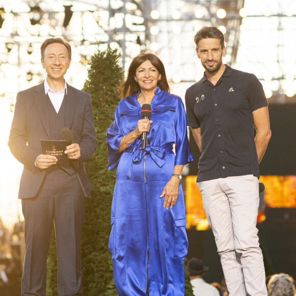 Exclusif - Stéphane Bern, Anne Hidaldo et Tony Estanguet lors du 10ème anniversaire du "Grand Concert de Paris" au pied de la Tour Eiffel sur le Champ-de-Mars à Paris, France, le 14 juillet 2023. © Perusseau-Veeren/Bestimage