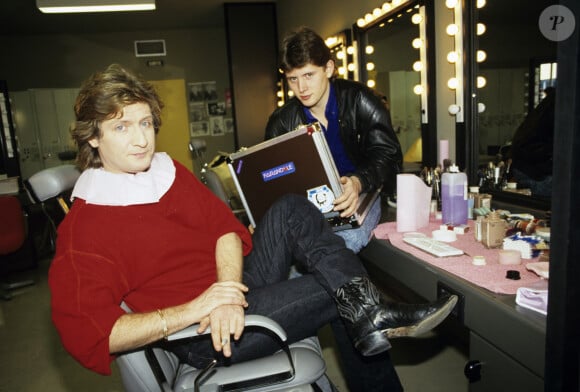 En France, à Paris, Patrick Sébastien dans sa loge, avec son fils Sebastien Boutot, 17 ans, qui tient une mallette portant l'inscription Farandole, lors d'un enregistrement de l'émission Farandole. Décembre 1987 © Alain Canu via Bestimage