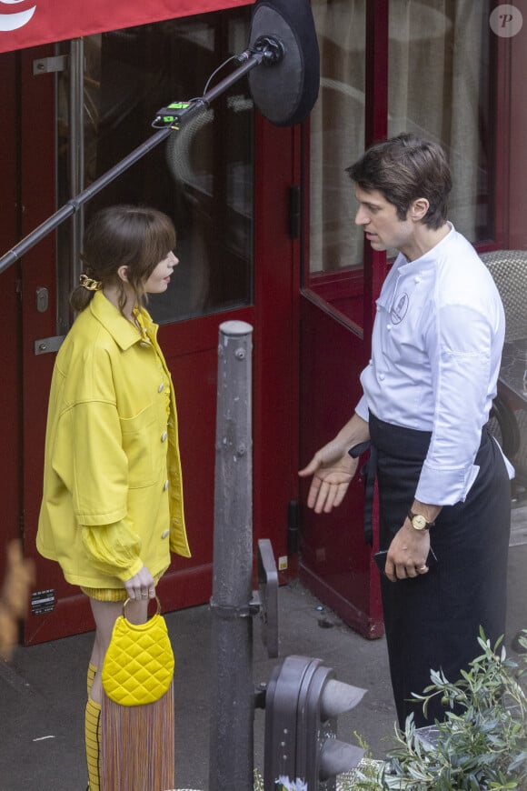 Lily Collins et Lucas Bravo sur le tournage de la saison 4 de série Netflix "Emily in Paris" devant le restaurant L'Esprit de Gigi à Paris, France, le 16 février 2024. 