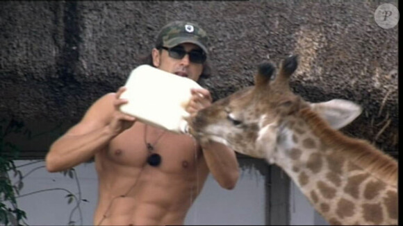 Greg donne le biberon au girafon.