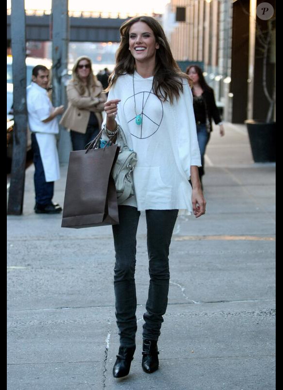 Alessandra Ambrosio choisi un top XXL, un jean moulant et des accessoires qui tuent. It-bag Balenciaga et collier coloré. Une ode à l'été.