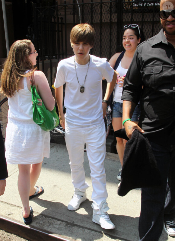 Justin Bieber quitte le Rockefeller Center, à New York, où il a donné un concert gratuit, et prend le temps de poser avec quelques fans, vendredi 4 juin.