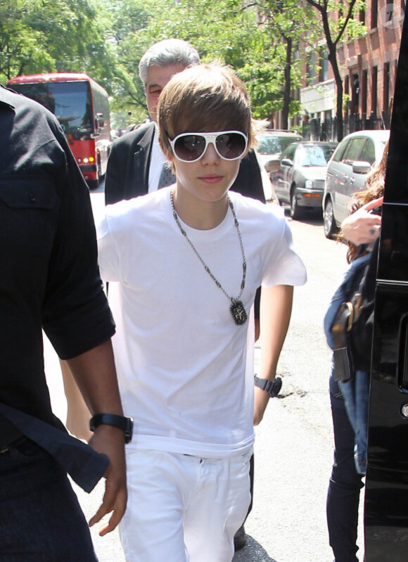Justin Bieber quitte le Rockefeller Center, à New York, où il a donné un concert gratuit, et prend le temps de poser avec quelques fans, vendredi 4 juin.