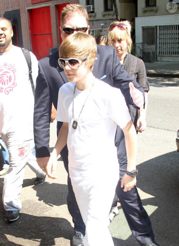 Justin Bieber quitte le Rockefeller Center, à New York, où il a donné un concert gratuit, et prend le temps de poser avec quelques fans, vendredi 4 juin.