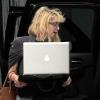 Courtney Love arrive avec ses chiens à Miami Beach et tente de se cacher derrière son ordinateur portable en juillet 2010