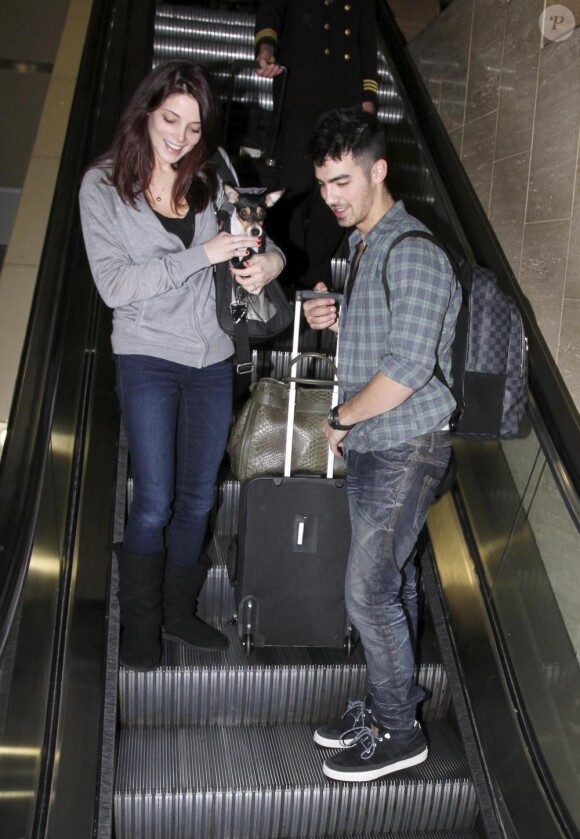 Joe Jonas (Jonas Brothers) et Ashley Greene reviennent de leur séjour à Disney World, et récupèrent leurs bagages à l'aéroport LAX de Los Angeles, le 29 décembre 2010.