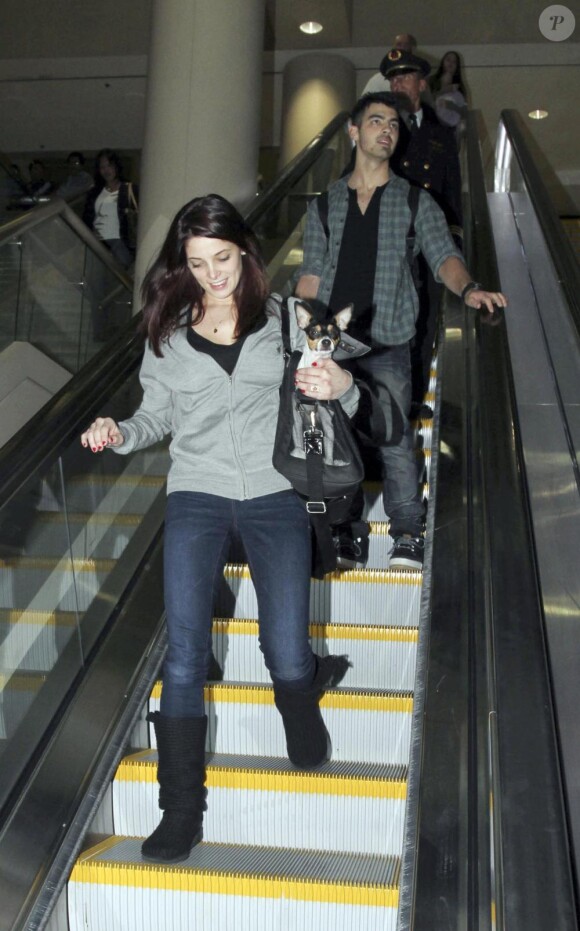 Joe Jonas (Jonas Brothers) et Ashley Greene reviennent de leur séjour à Disney World, et récupèrent leurs bagages à l'aéroport LAX de Los Angeles, le 29 décembre 2010.
