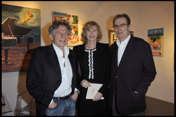 Roman Polanski, Dean Tavoularis et son épouse Aurore à la galerie parisienne Catherine Houard, lors de l'exposition "Magicien d'Hollywood, le cinéma dans la peinture, la peinture dans le cinéma". 17/03/2011