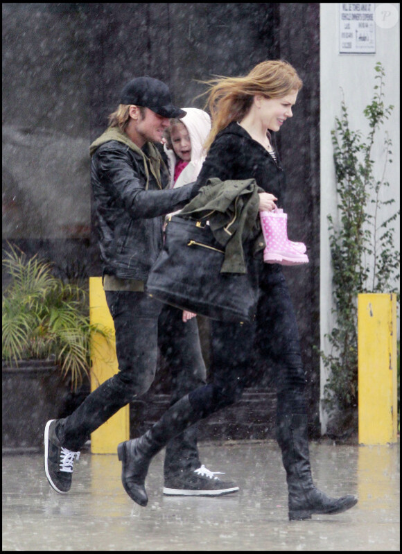 Nicole Kidman, Keith Urban et leur petite Sunday Rose, deux ans, tentent d'échapper à la pluie, et de regagner leur voiture au plus vite, dimanche 20 mars à Los Angeles.