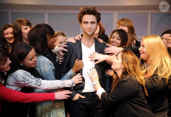 Des groupies entourent la statue de cire de Robert Pattinson au musée de Madame Tussauds à Londres le 25 mars 2010