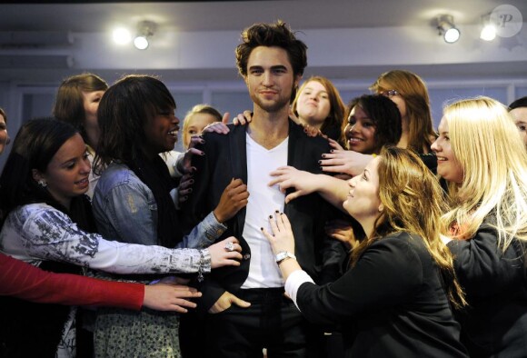 Des groupies entourent la statue de cire de Robert Pattinson au musée de Madame Tussauds à Londres le 25 mars 2010