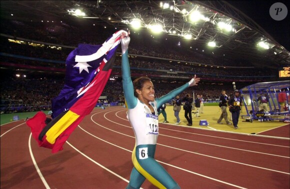 Cathy Freeman le 24 février 2000. Après avoir gagné le 400m, elle a célébré sa victoire avec les drapeaux australien et aborigène