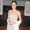 Angelina Jolie tente de féminiser sa garde robe mais a encore du mal à trouver le style qui convient à sa silhouette svelte. Los Angeles, 1998