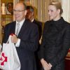 La princesse Charlene de Monaco, auprès de son mari le prince Albert et la princesse Stéphanie, vivait le 17 novembre 2011 sa première distribution de sacs alimentaires dans les locaux de la Croix Rouge monégasque.