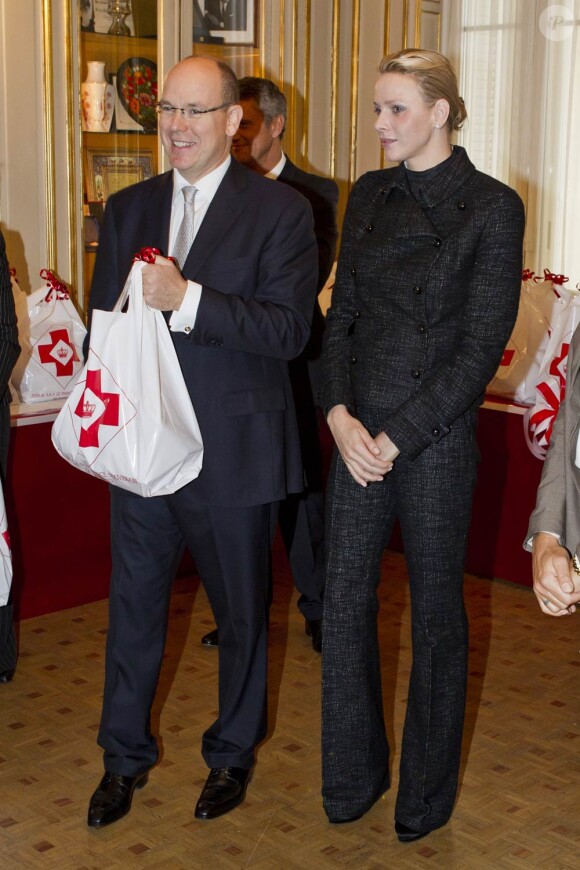 La princesse Charlene de Monaco, auprès de son mari le prince Albert et la princesse Stéphanie, vivait le 17 novembre 2011 sa première distribution de sacs alimentaires dans les locaux de la Croix Rouge monégasque.