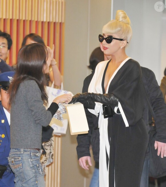 Lady Gaga prend le temps de signer quelques autographes avant de s'envoler pour New York. Aéroport de Narita, le 24 décembre 2011.
