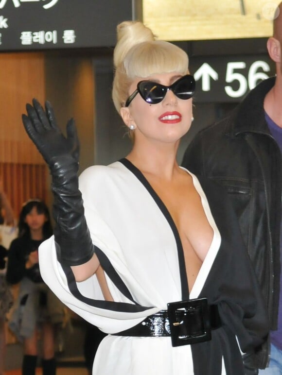Lady Gaga salue ses fans et les photographes à l'aéroport de Narita, le 24 décembre 2011.