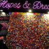 Meilleurs voeux de New York ! Une jeune femme écrit son voeu sur un morceau de confetti qui rejoint tous ceux déjà affichés sur un mur à Times Square. 