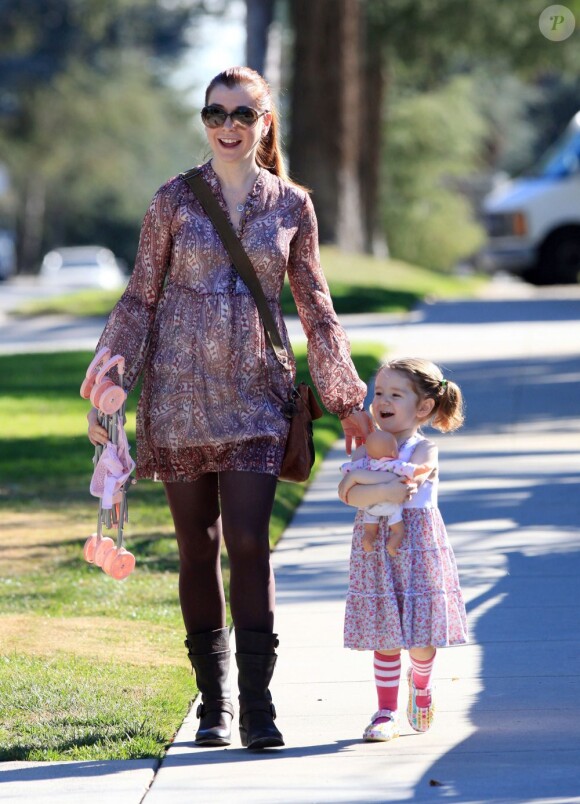 Alyson Hannigan et sa fille, souriantes devant les photographes à Los Angeles, le 5 janvier 2012.